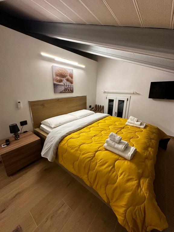 1 dormitorio con 1 cama amarilla y 2 toallas en Wild bed & breakfast, en Fiorano Modenese