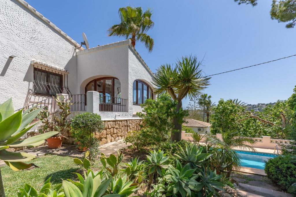 a villa with a swimming pool and a house at Villa Maria in Jávea