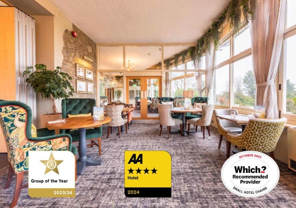 un comedor con mesas, sillas y ventanas en The Moorland Hotel, Haytor, Devon, en Haytor