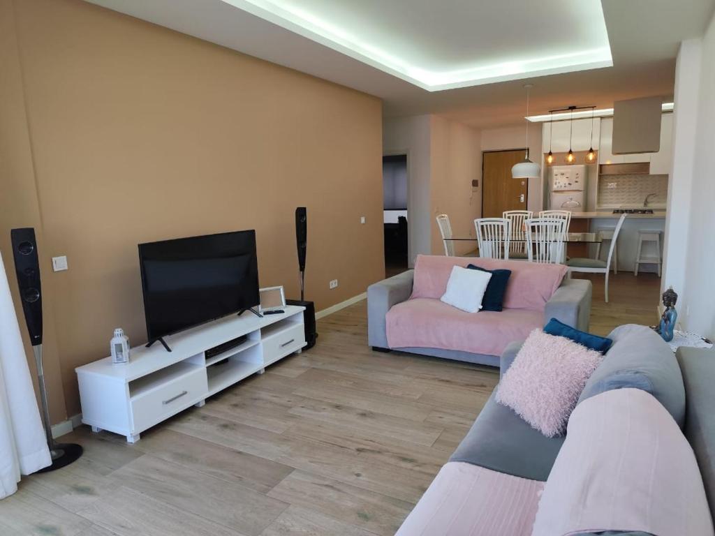 sala de estar con sofá y TV de pantalla plana en Isa Charme Home, en Praia