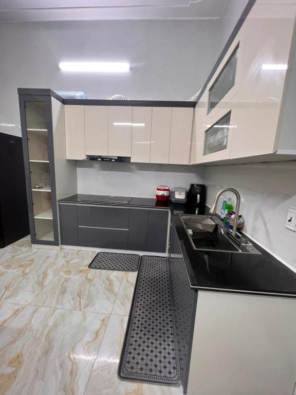 uma cozinha com armários a preto e branco e um lavatório em Eco House em Ilha de Cát Bà