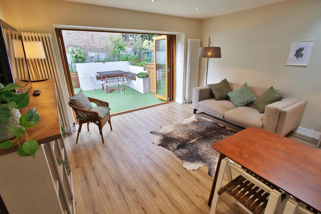een woonkamer met een bank en een tafel bij Peaceful Garden Apartment on Roman Road in Londen