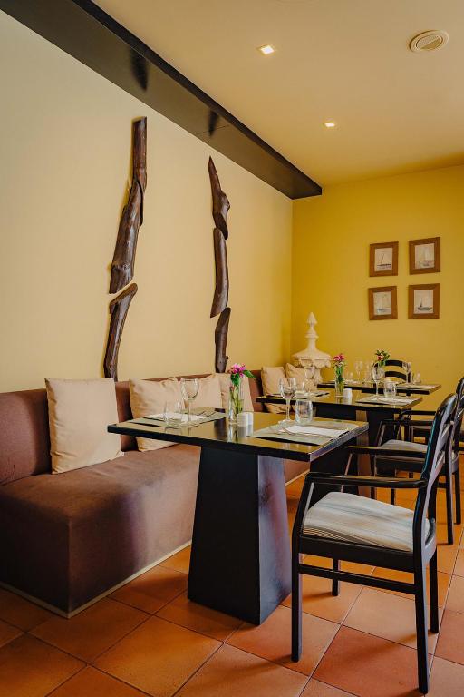 a restaurant with two tables and a couch and chairs at Calheta Beach - All-inclusive - Savoy Signature in Calheta