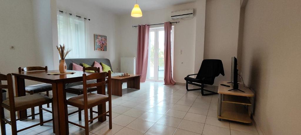 a living room with a dining table and a television at KANALI HOLIDAYS APARTMENT in Kanali