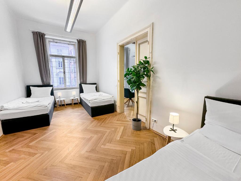 feworld - big living - city center Klagenfurt في كلاغنفورت: غرفة نوم بسريرين وارضية خشبية