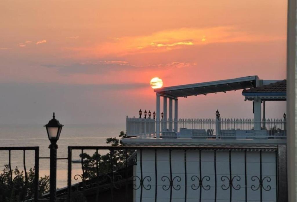 een zonsondergang boven de oceaan met een pier op de achtergrond bij Beachway Hotel Side in Side