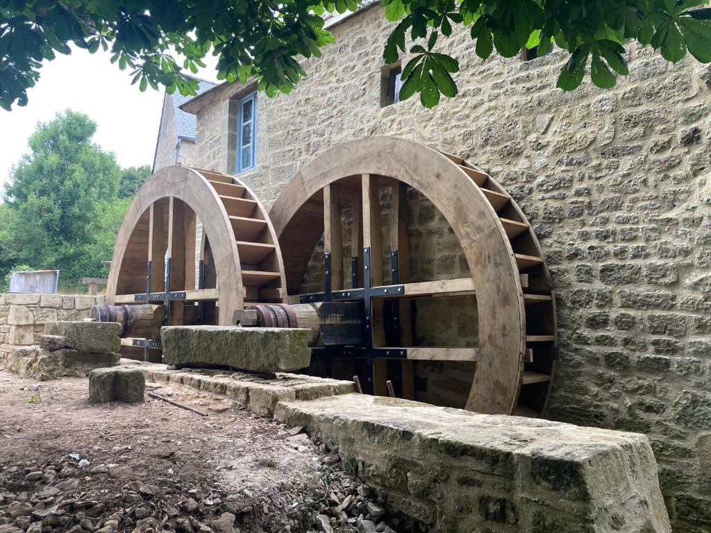 un bâtiment en briques avec un tas de tonneaux de vin dans l'établissement Miller house in a water mill from the 12th century, à Négreville