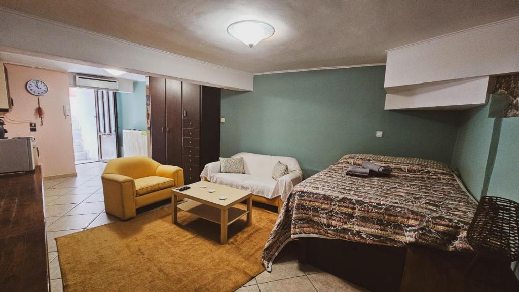 une chambre avec un lit, un canapé et une chaise dans l'établissement Stone cottage, à Chalcis