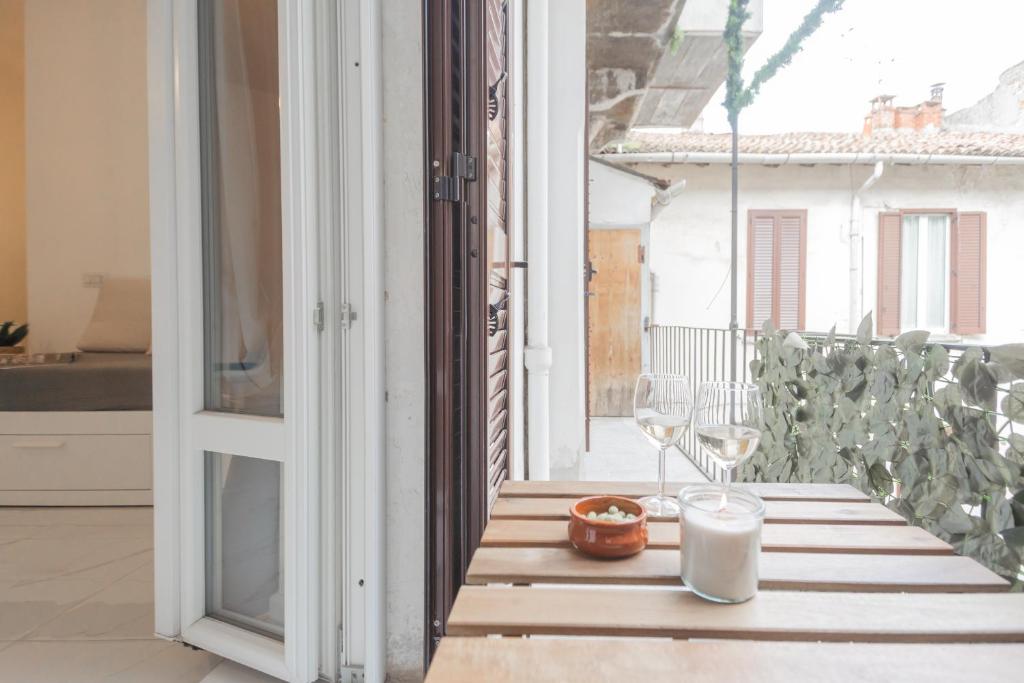 uma mesa numa varanda com um copo de vinho em Luce Apartment by Rent All Como em Como