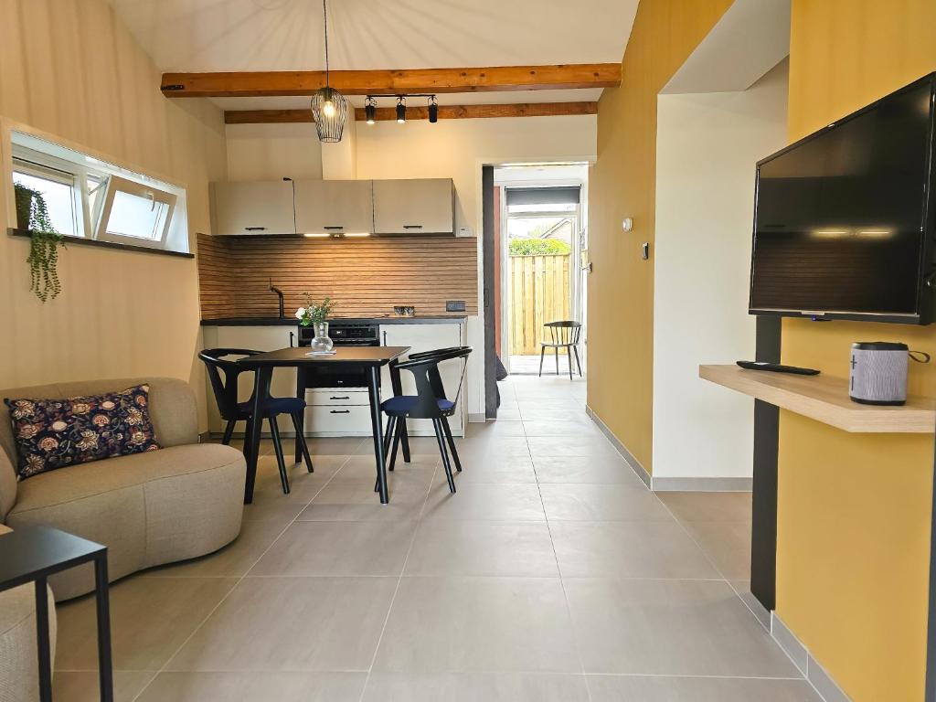 a living room and kitchen with a table and a couch at Vakantiehuis 'Lodge 22' Oostkapelle OK18 in Oostkapelle