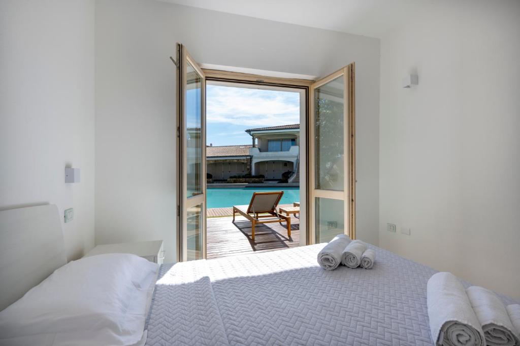 a bedroom with a bed and a view of the pool at Sardinia Gold Luxury Apartment in Palau
