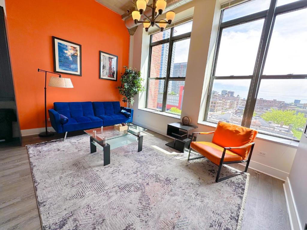 - un salon avec un canapé bleu et des murs orange dans l'établissement McCormick 2Br/2Ba family unit for up to 6 guests with Optional Parking & Gym access, à Chicago