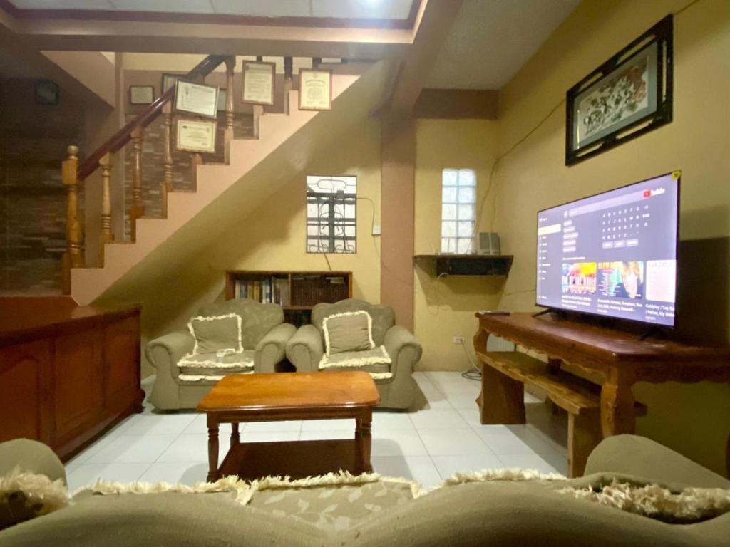 sala de estar con piano y escalera en Baguio mountain villa view LW, en Baguio