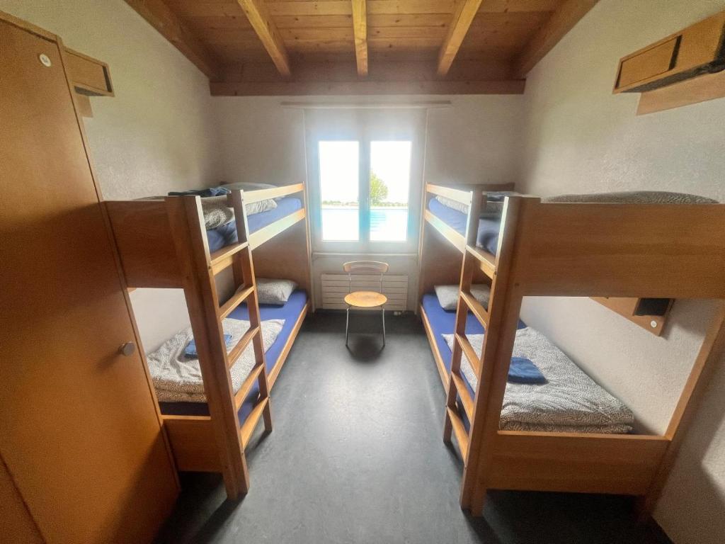 a room with three bunk beds and a window at Herberge-Unterkunft-Seeperle in Rorschach in Rorschach