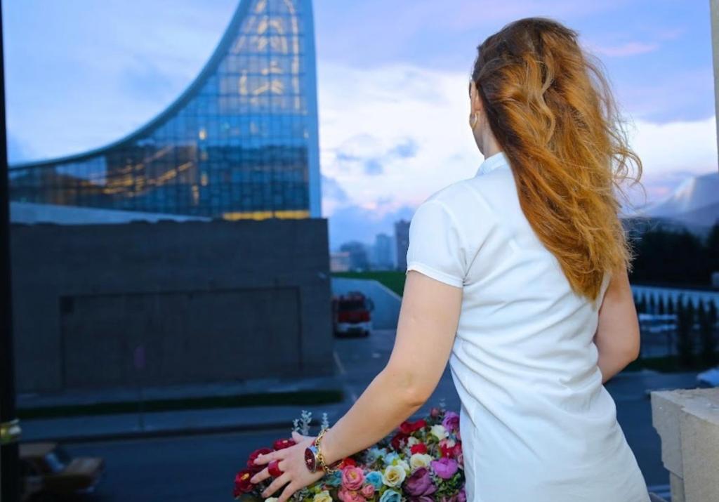 uma mulher ruiva com vista sobre uma cidade em Grand Inn Baku Hotel em Baku