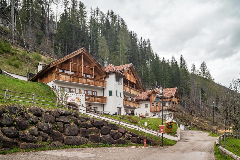 a large building on a mountain with a road at Apartments Mirabell in Livinallongo del Col di Lana