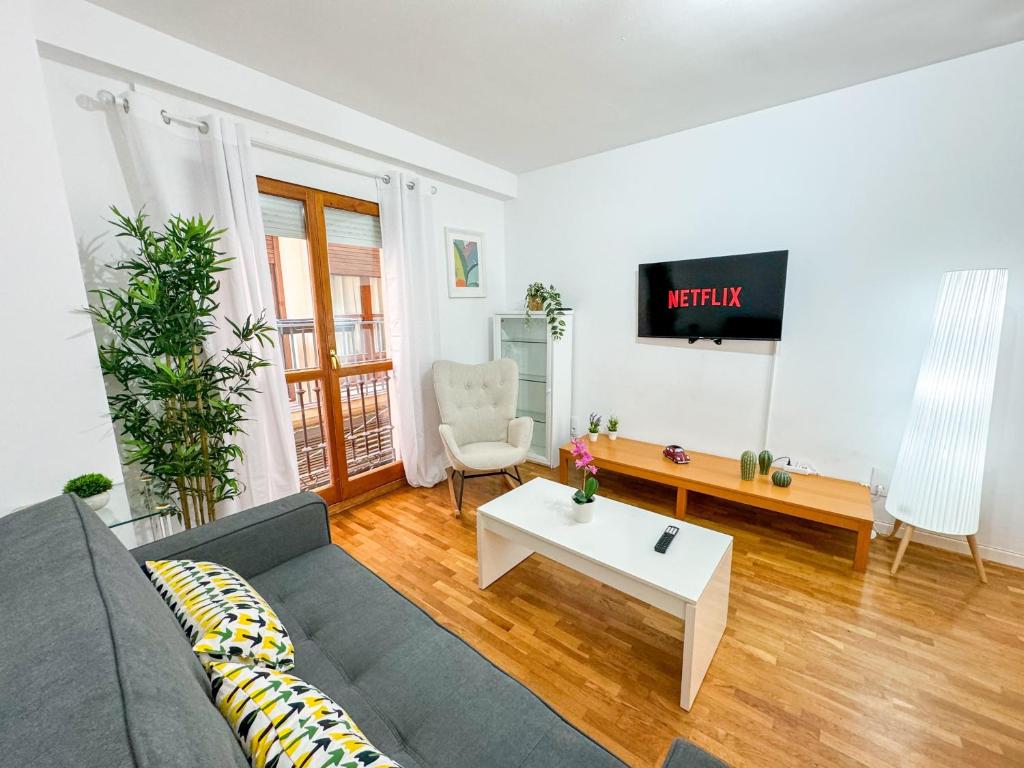 uma sala de estar com um sofá e uma mesa em Laurel del Pilar ComoTuCasa em Zaragoza