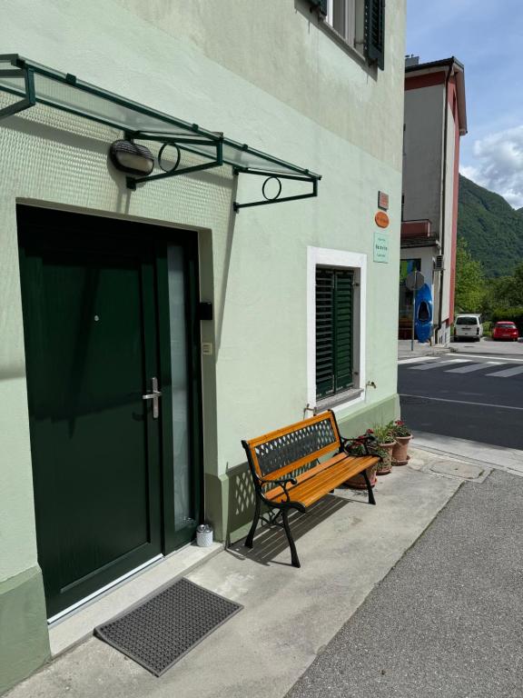 a wooden bench sitting outside of a building with a door at Belavita in Bovec