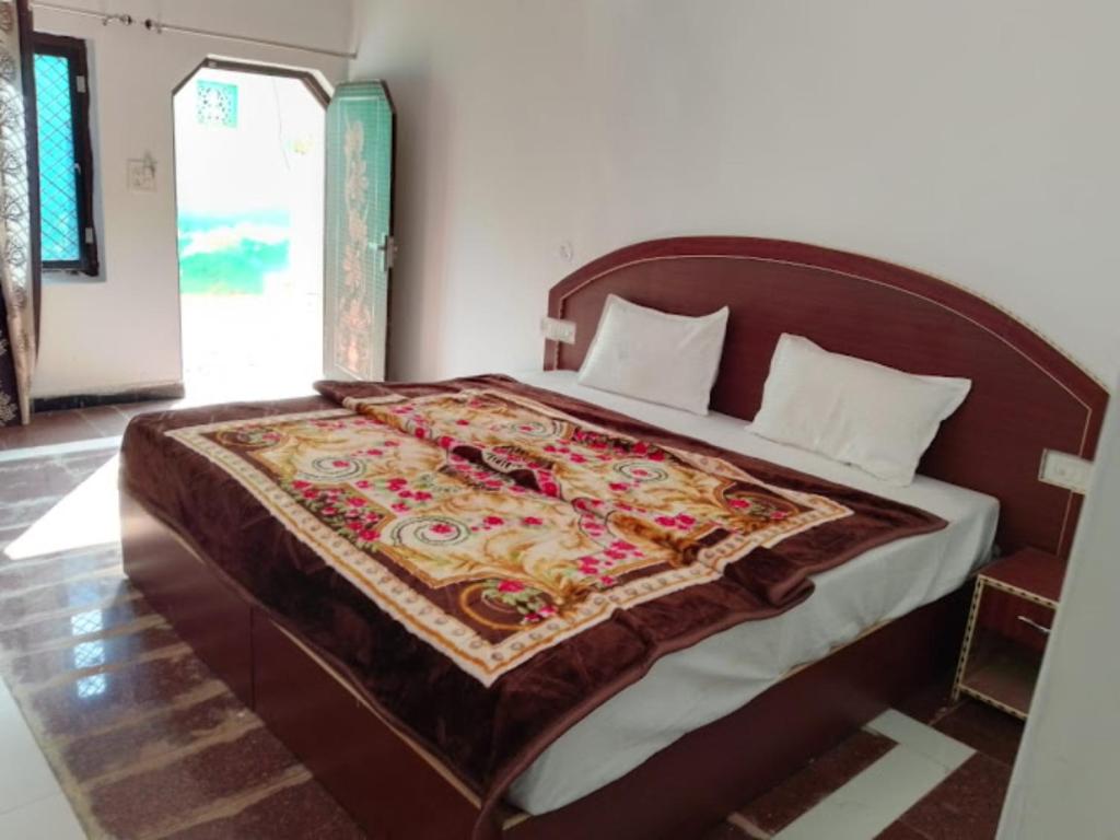 Un dormitorio con una cama grande con una manta. en Goroomgo Hotel Happy Home Stay Khajuraho en Khajurāho
