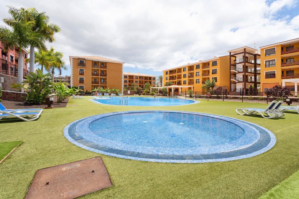 Una gran piscina en medio de un patio. en Apto El Mocan Swimming Pool 2bed, en Palm-mar