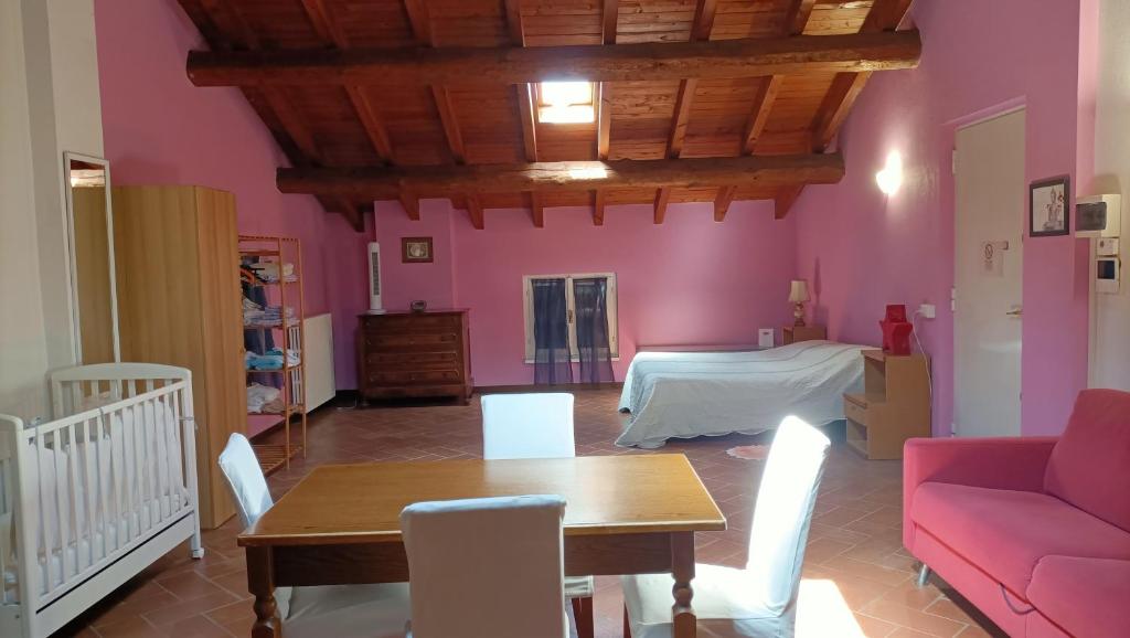 een woonkamer met roze muren en een tafel en een bed bij B&B Il Loto in Vailate