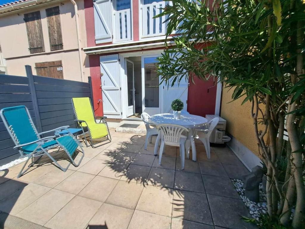 une table et des chaises assises sur une terrasse dans l'établissement Charmante maison 2 pièces cabine 6 personnes, proche mer et étang, terrasse avec BBQ - FR-1-326-752, à Marseillan