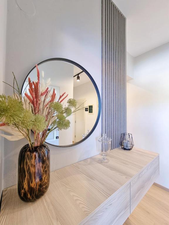 a vase with flowers on a table in front of a mirror at Studios Despina in Limenaria