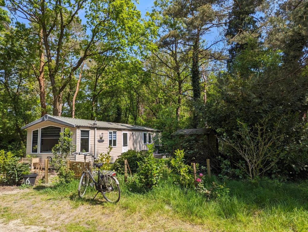 a white tiny house in the middle of a field at Ruim Chalet, midden in het bos! in Nunspeet