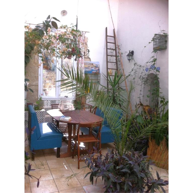 un patio avec une table, des chaises et des plantes dans l'établissement La Comtadine d'Oc, à Argeliers