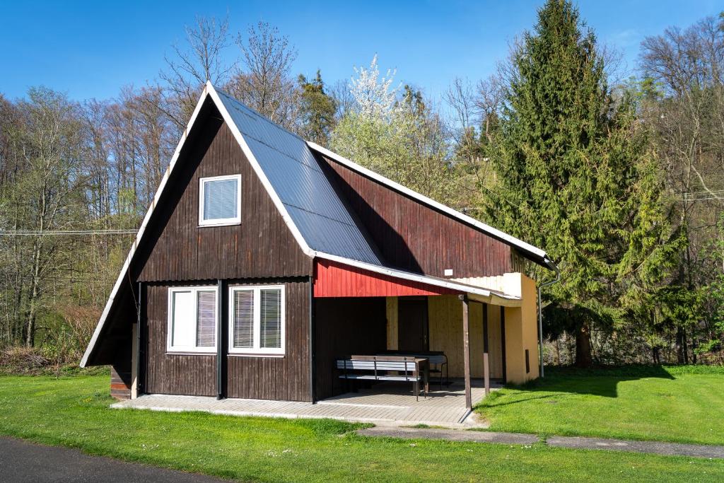 a barn with a bench in front of it at Chatka na hřišti TJ Sokol in Ostravice