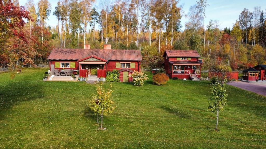una casa roja en medio de un patio en Mysigt HÄRBRE STUGA med utsikt över Siljan en Rättvik
