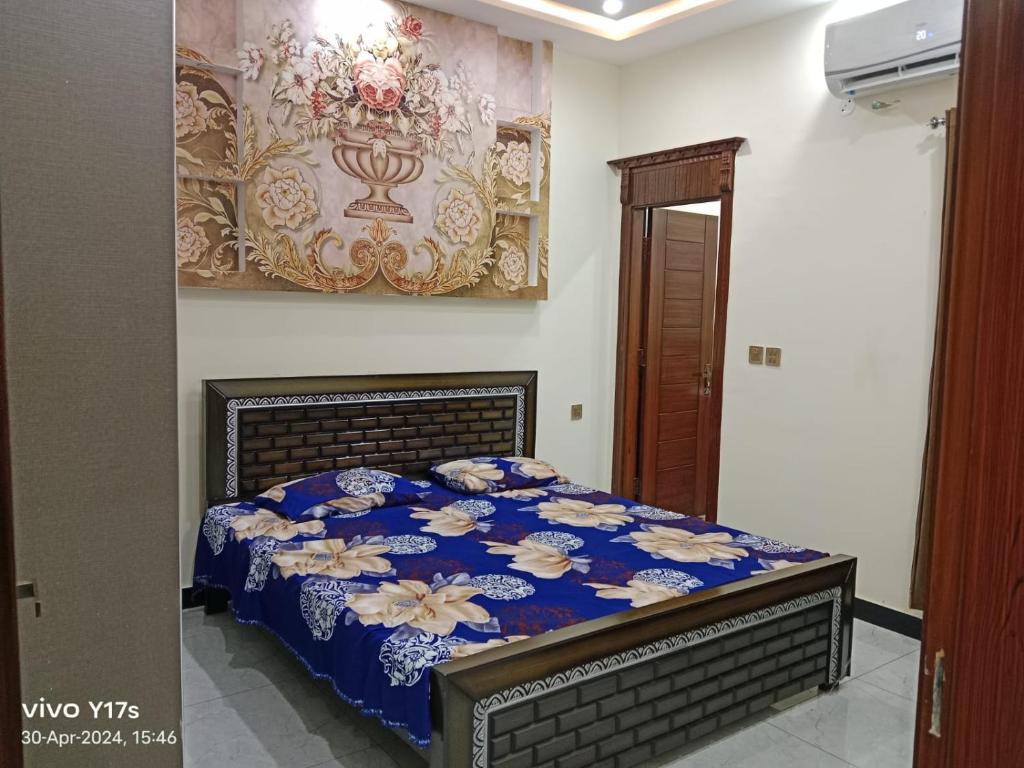 sypialnia z łóżkiem z niebieską kołdrą w obiekcie Shah jee guest house w mieście Jhelum