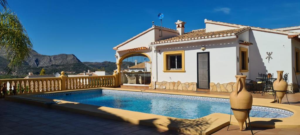 eine Villa mit einem Pool vor einem Haus in der Unterkunft Villa El Huerto in Orba