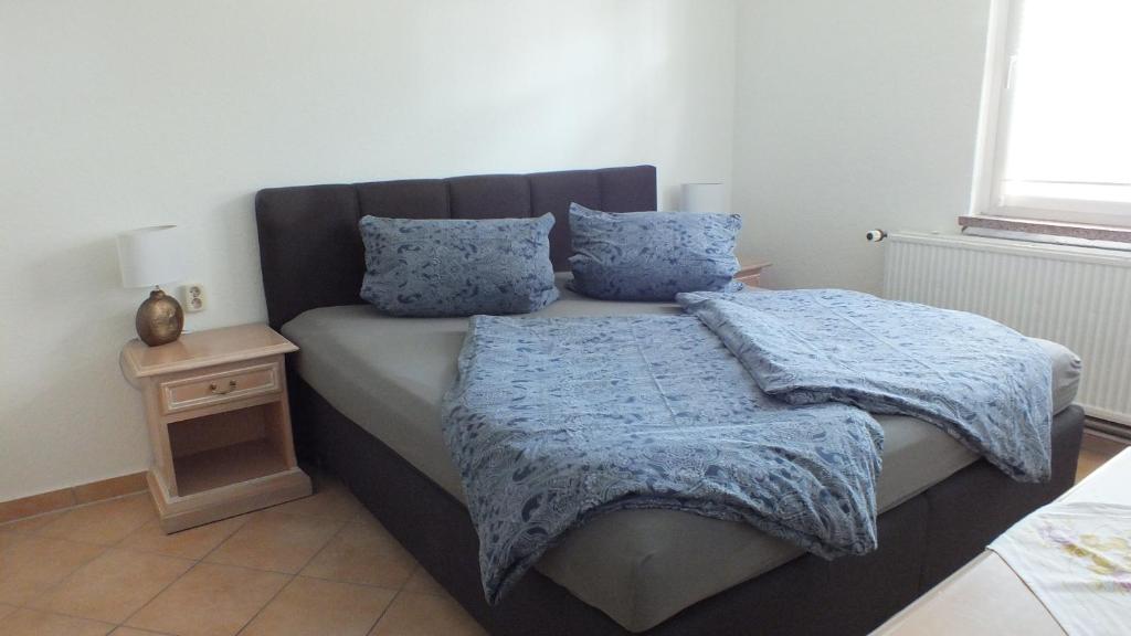 1 dormitorio con 1 cama con almohadas azules y mesita de noche en Zimmer im Ferienpark Buntspecht, en Pruchten