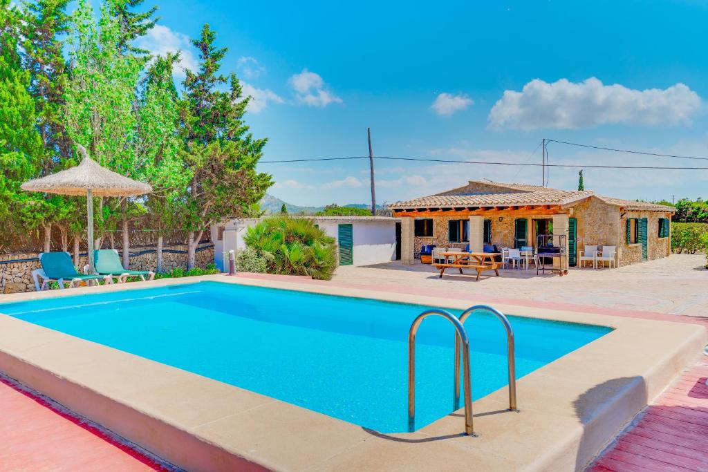 una piscina en un patio con una casa en Finca ROTES Pollensa, en Puerto Pollensa