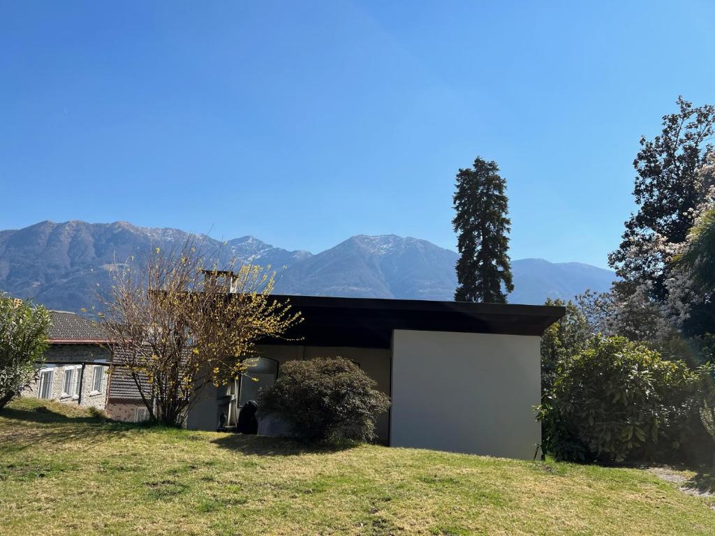 a house with a garage with mountains in the background at Muralto-Locarno: Miramonti Apt. 4 in Locarno