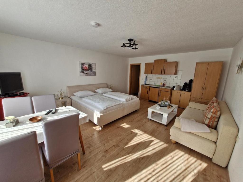um quarto com uma cama, uma mesa e um sofá em Ferienwohnung Schulzental em Ilmenau