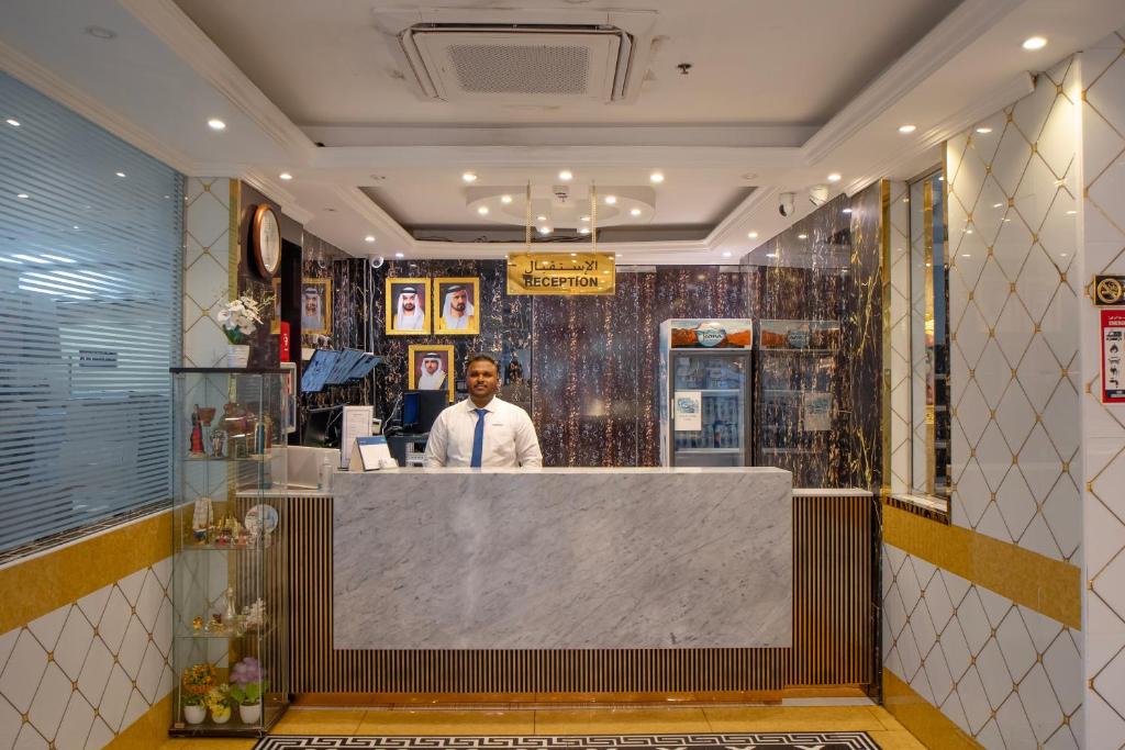 a man standing at a counter in a restaurant at AL KARNAK HOTEL - BRANCH in Dubai