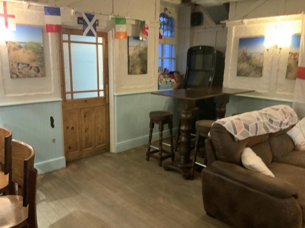 a living room with a table and a couch at Wayfarer Inn in Instow
