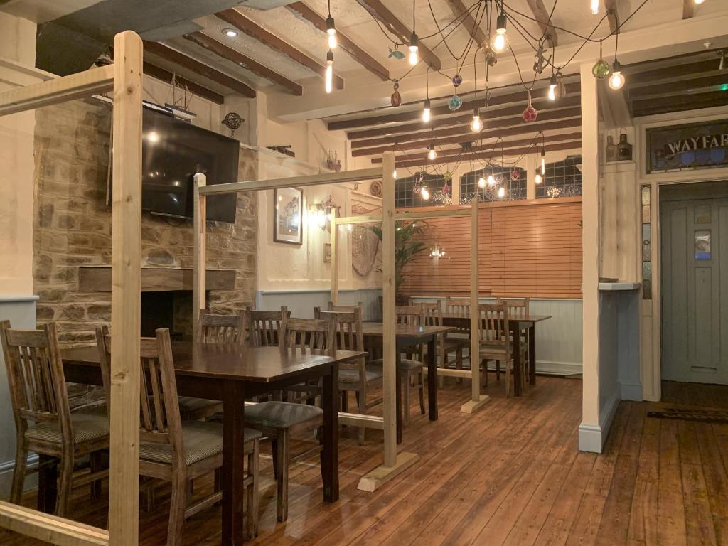a dining room with tables and chairs and a fireplace at Wayfarer Inn in Instow