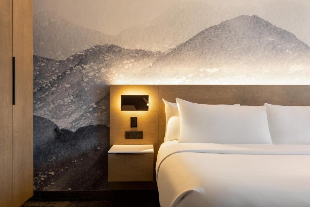 a hotel room with a bed and a mountain mural at Hôtel Québec Best Western PLUS Centre-Ville - City Center in Quebec City