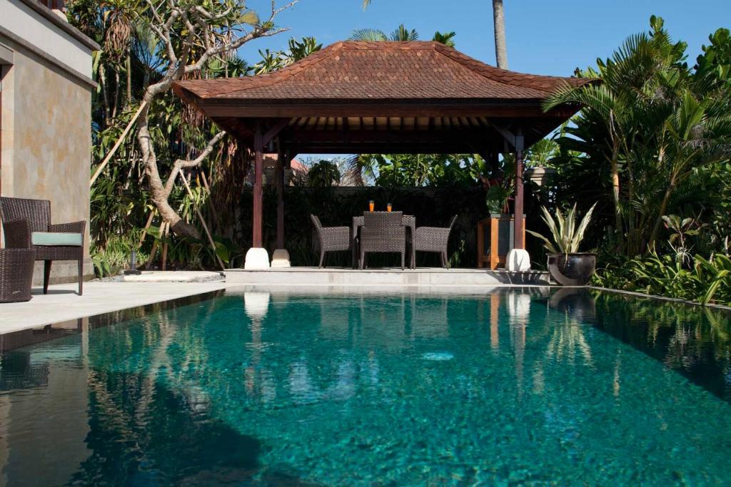 a swimming pool with a gazebo in a backyard at Villa Sundara in Tanah Lot