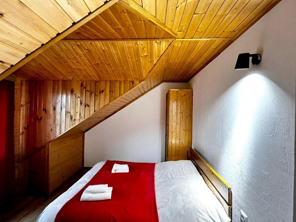a bed in a room with a wooden ceiling at Nino & Irodi's Guest House in Kutaisi