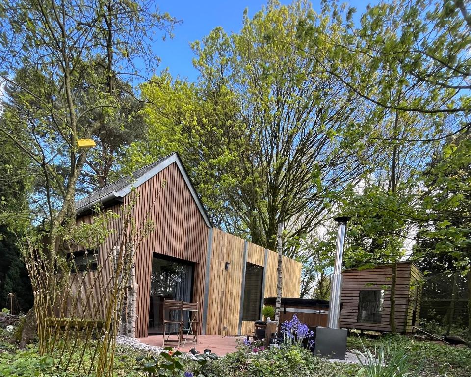 にあるLépylogueの木の植わる庭の小さな木造家屋