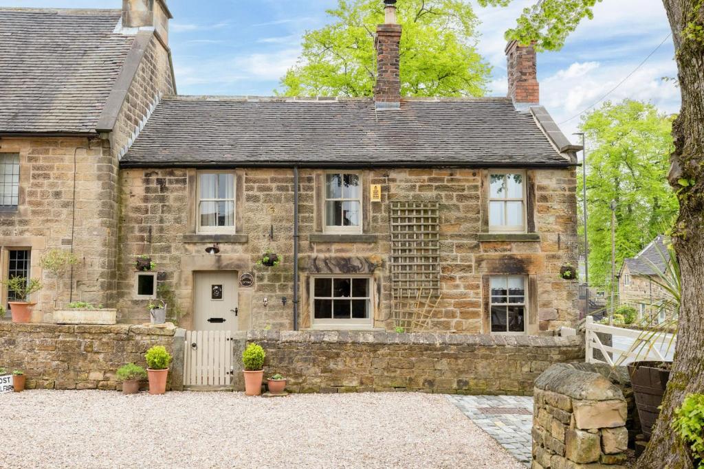 an old stone house with a driveway in front of it at Host & Stay - Well Farm Cottage in Higham
