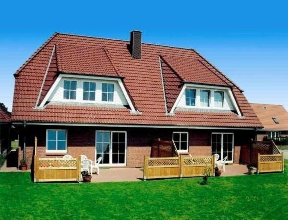 海利根港Gepflegte Erdgeschossferienwohnung in Heiligenhafen的院子内有长椅的大房子