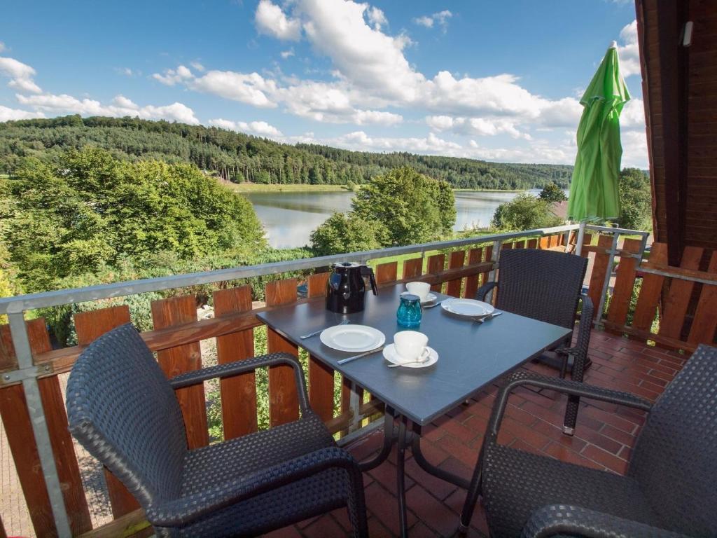 una mesa y sillas en una terraza con vistas al río en Komfortable Ferienwohnung mit Seeblick - b56594, en Bad Arolsen