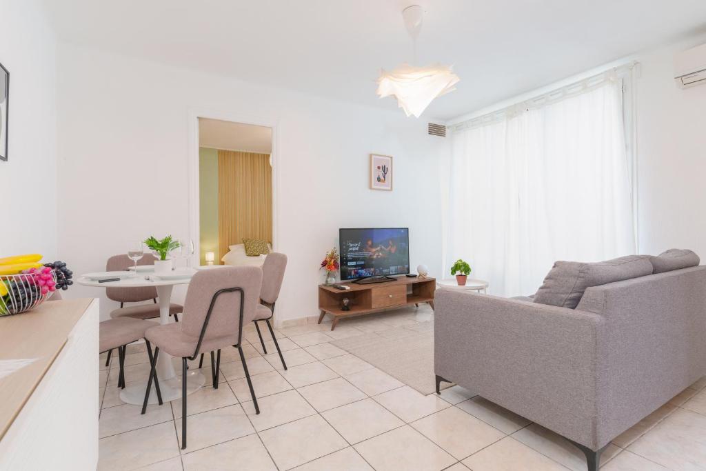 een woonkamer met een bank en een tafel bij Le Gabin By ApiRent #Centre-ville #Climatisation #Wifi in Cannes