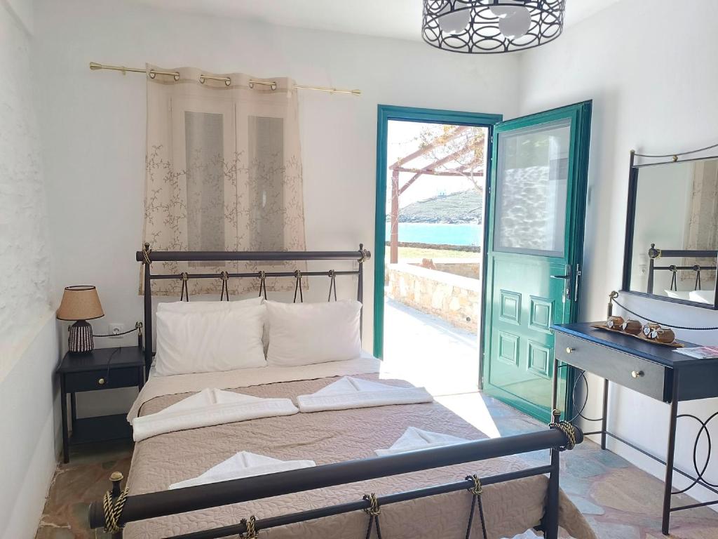um quarto com uma cama com um espelho e uma janela em Simousi Studio 1, On the Beach! Kythnos em Kythnos