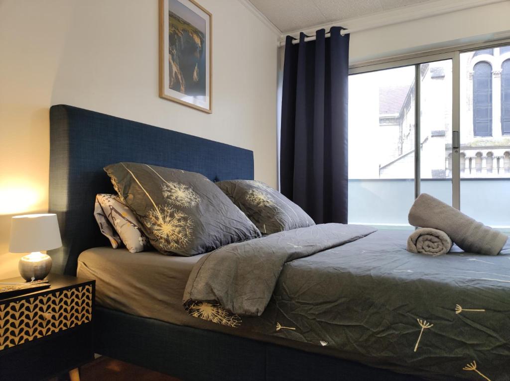 une chambre avec un lit avec des oreillers et une fenêtre dans l'établissement Trocadéro suite Paris 16ieme - with balcony, à Paris